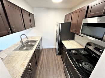 A kitchen with brown cabinets and a black stove top oven.